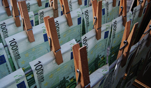 foto van 100 euro bankbiljetten die met houten knijpers aan een waslijn hangen